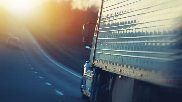 White Rig Driving on a Highway at Sunset