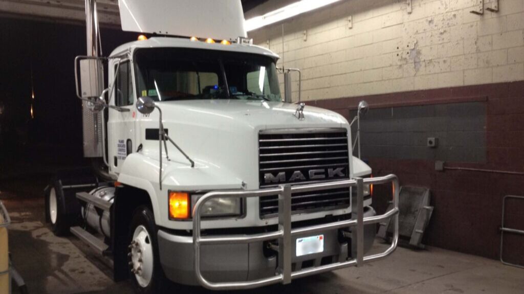 White Mack Truck with RIGGUARD Grille Guard in a Garage