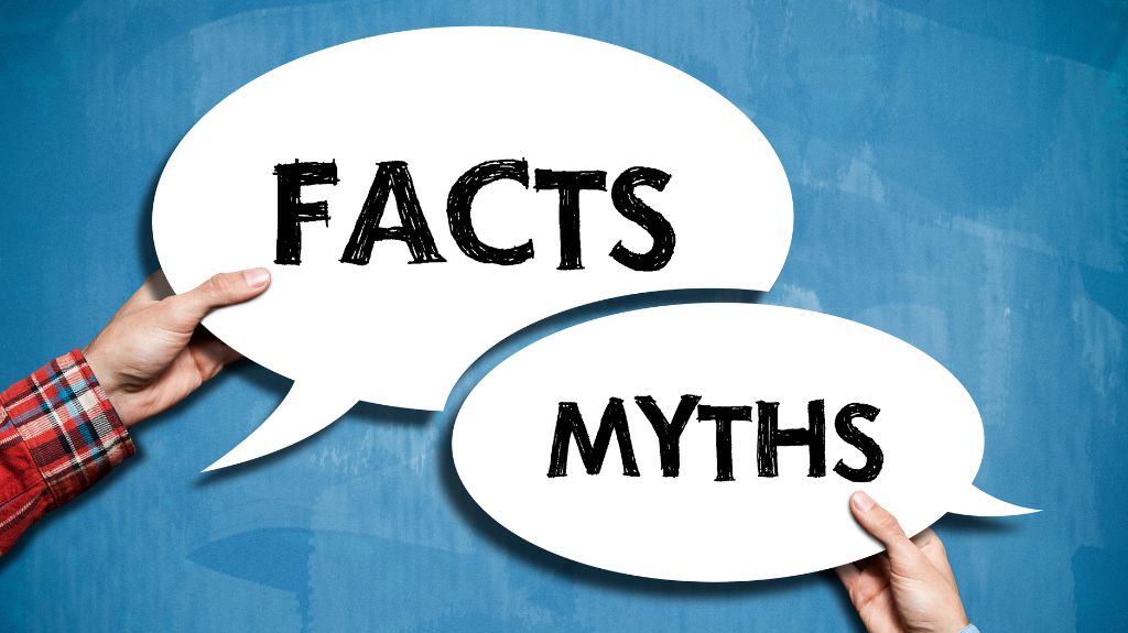 Hands Holding Speech Bubbles with Facts and Myths Texts